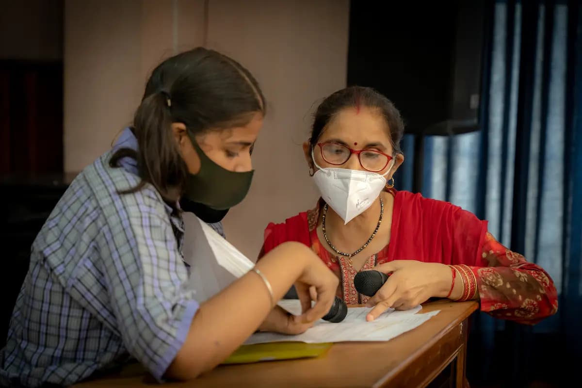 A teacher working one-on-one with a student at a desk