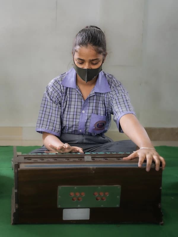 A student practicing the harmonium in the music room