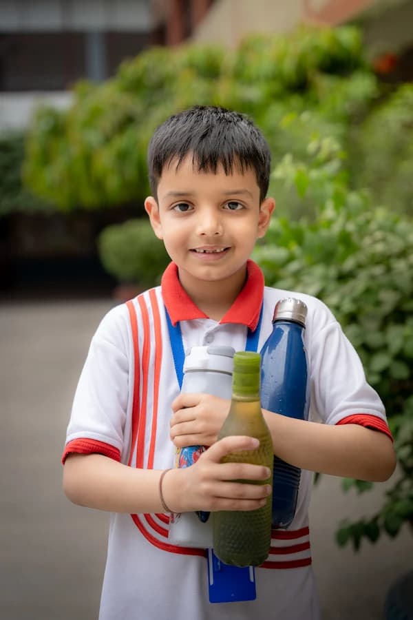 A senior student in glasses smiling outside the classrooms