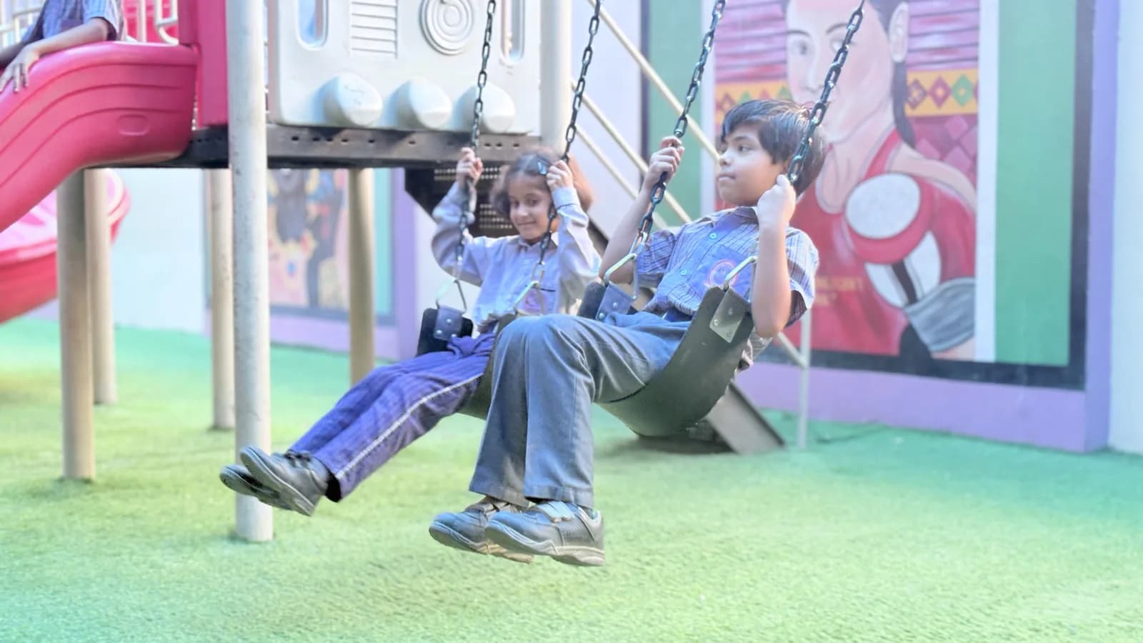 Children on the swings at the new covered playground, Udaya Public School, Ayodhya